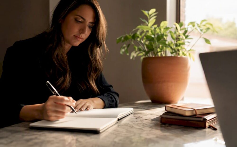 Woman writing notes during leadership coaching