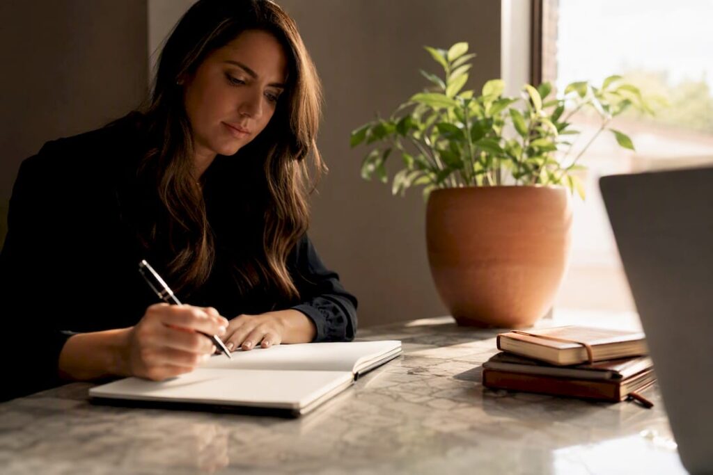 Woman writing notes during leadership coaching