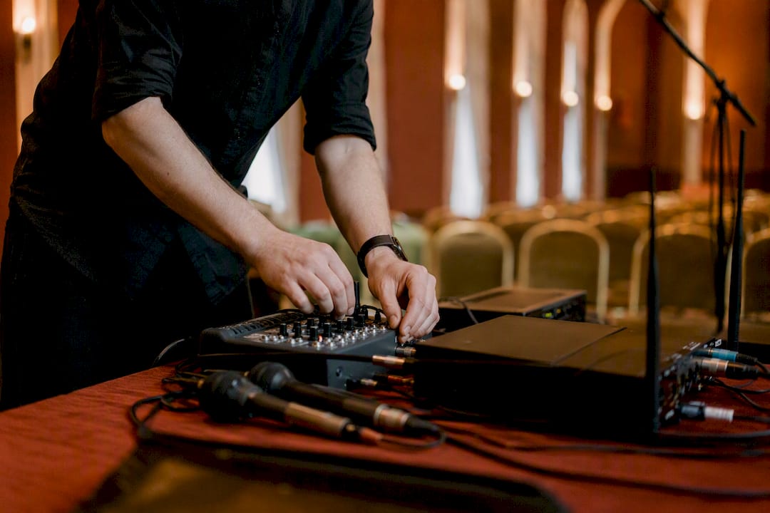 Stage manager hands adjusting AV equipment