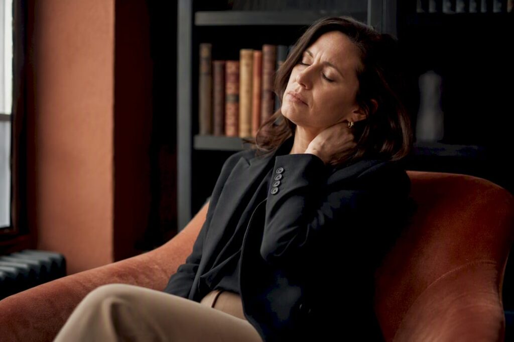 Woman massaging temples showing burnout tension