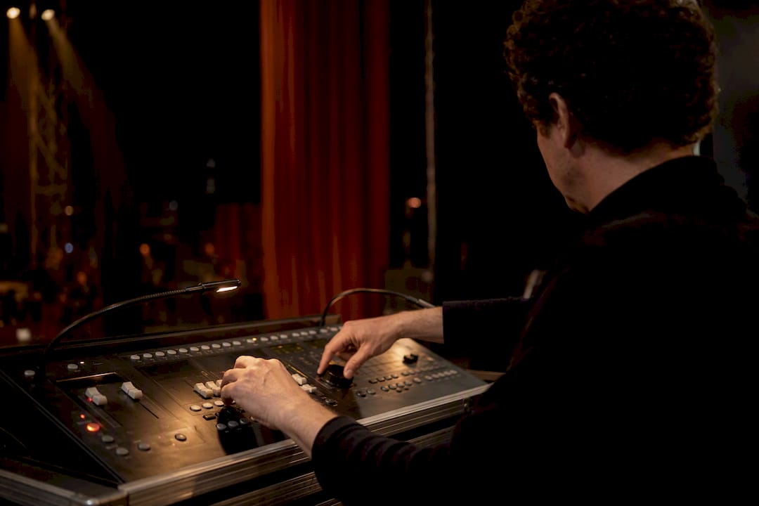 Technician adjusting stage light during rehearsal