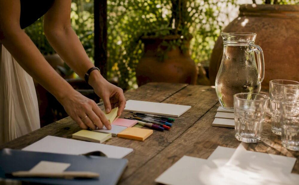 Hands arranging sticky notes on table