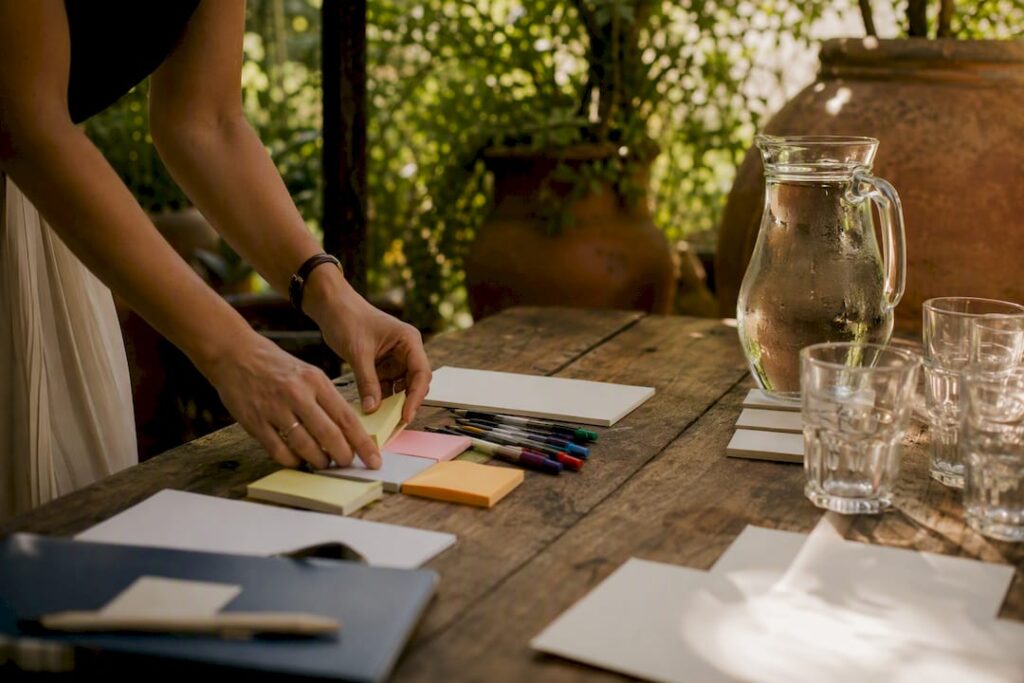 Hands arranging sticky notes on table