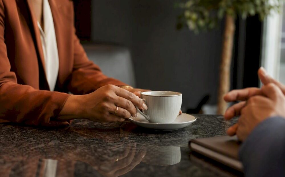 Manager setting coffee cup during coaching session