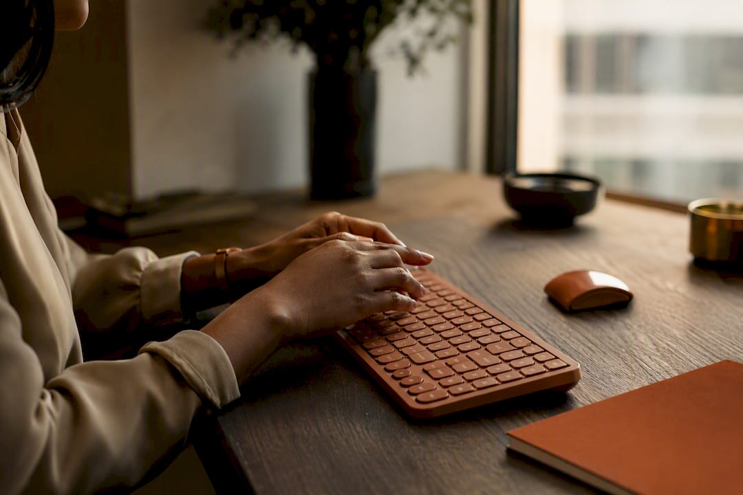 Hands pausing over keyboard in reflection
