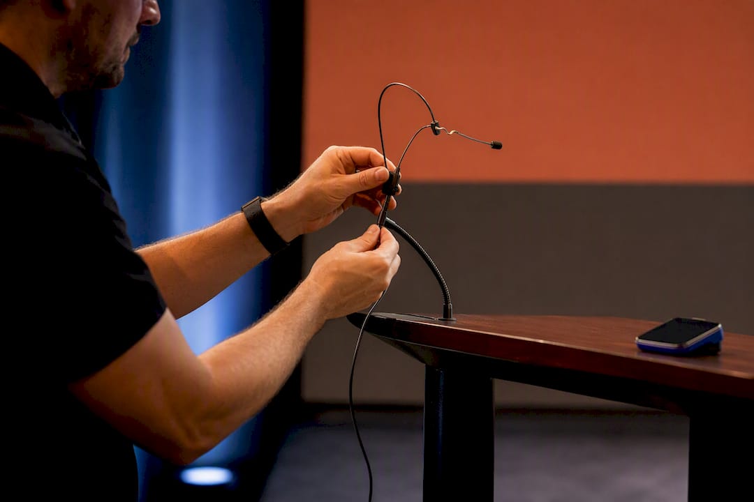 Technician adjusting microphone for rehearsal