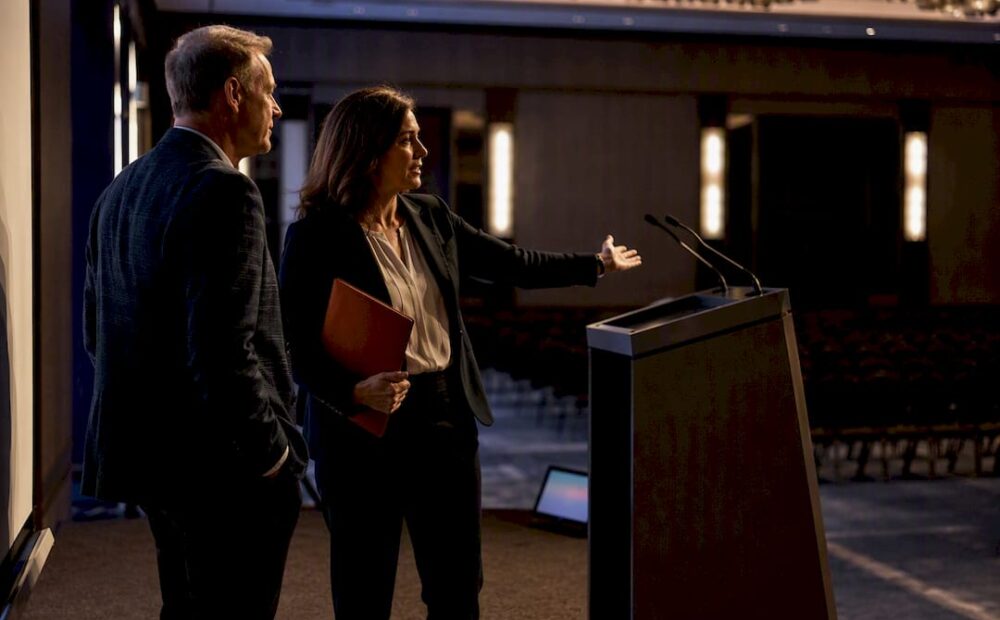 Planner and speaker reviewing event stage setup