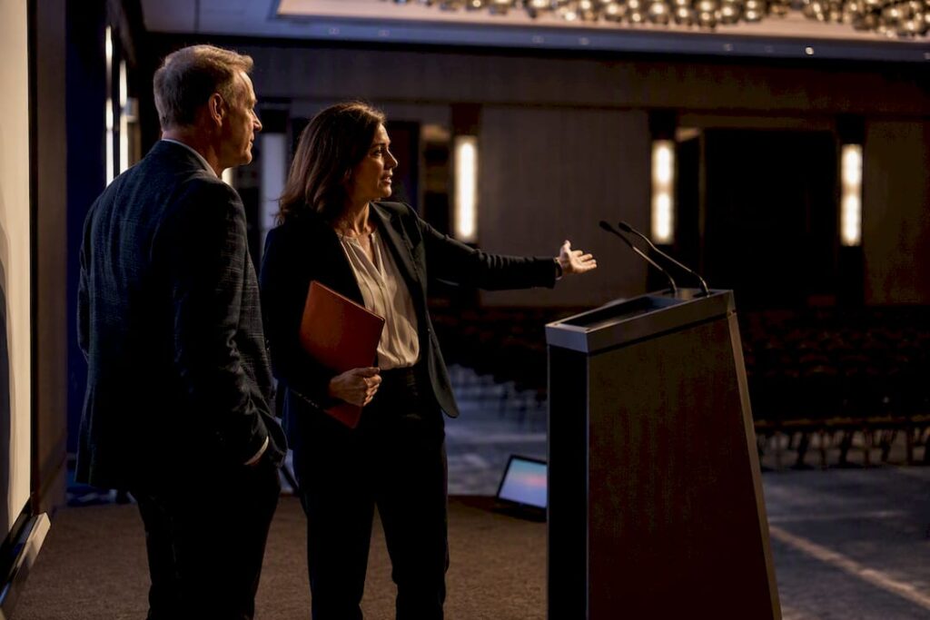 Planner and speaker reviewing event stage setup